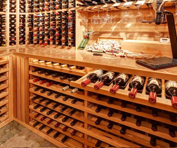 Intérieur d’une cave à vins avec bouteilles alignées sur étagères au restaurant La Table de 3 à Bordeaux